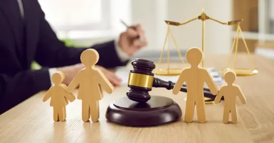 wooden figures of parents and children placed on desk in courthouse